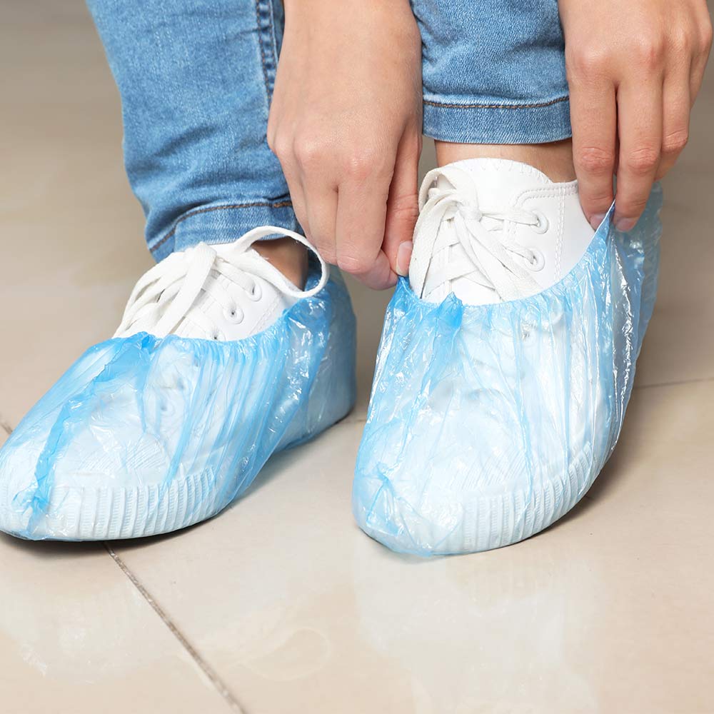 Einweg-Schuhüberzieher, blaue Überzieher über Sneakern, mit rutschhemmender Sohle