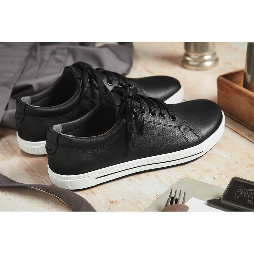Schwarzer Sneaker aus Naturleder mit Schnürung und weißer Sohle, Nahaufnahme
