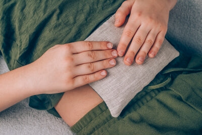Un garçon utilise un coussin aux graines sur son ventre