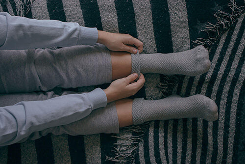 Enfiler des chaussettes au lit