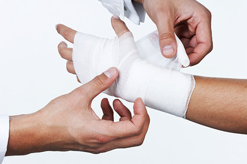 Un médecin enveloppe un bandage avec une bande de rembourrage