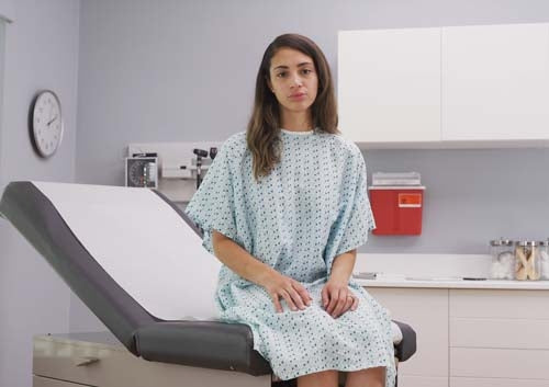 A patient sitting on a treatment table with doctor's crepe paper