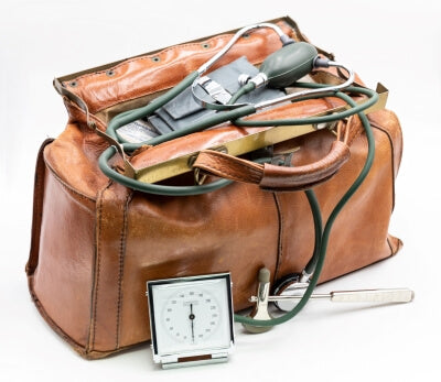 Un sac de médecin en cuir véritable avec un stéthoscope posé dessus, devant un fond blanc.
