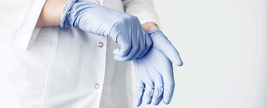 Un médecin enfile des gants jetables en vinyle