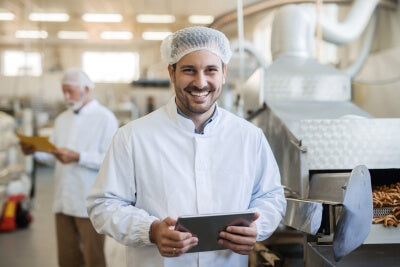 Homme utilisant une tablette pour effectuer un contrôle d’hygiène avec les indicateurs de germes schülke
