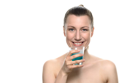 Femme avec un verre de solution de rinçage buccal